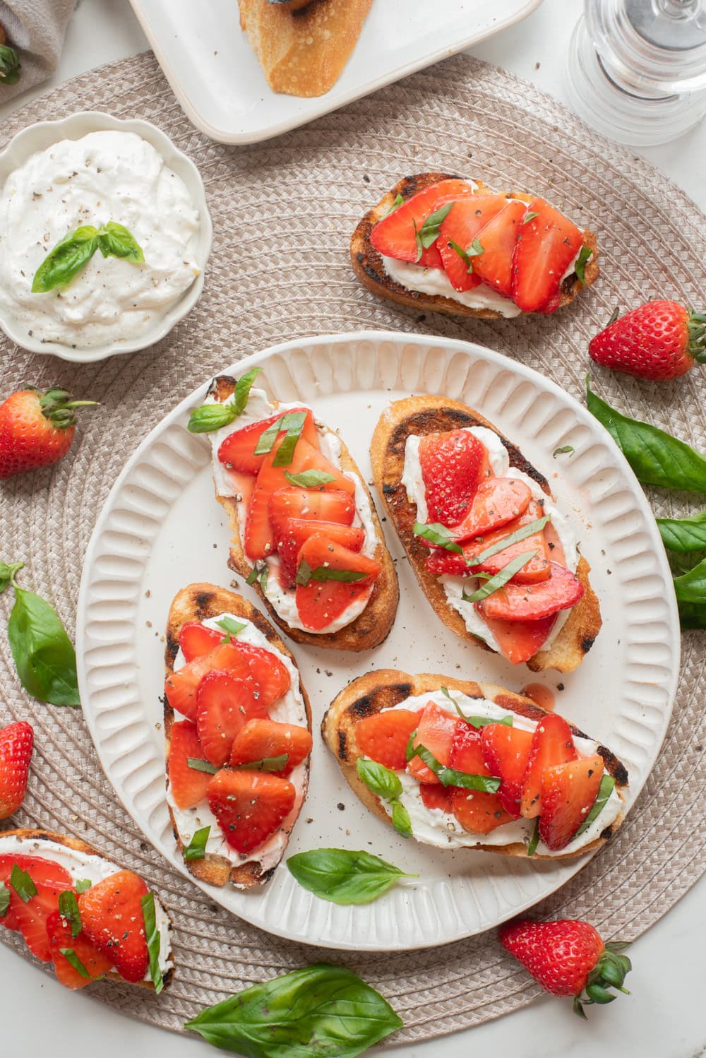 Finished strawberry basil whipped ricotta bruschetta arranged on a serving platter.
