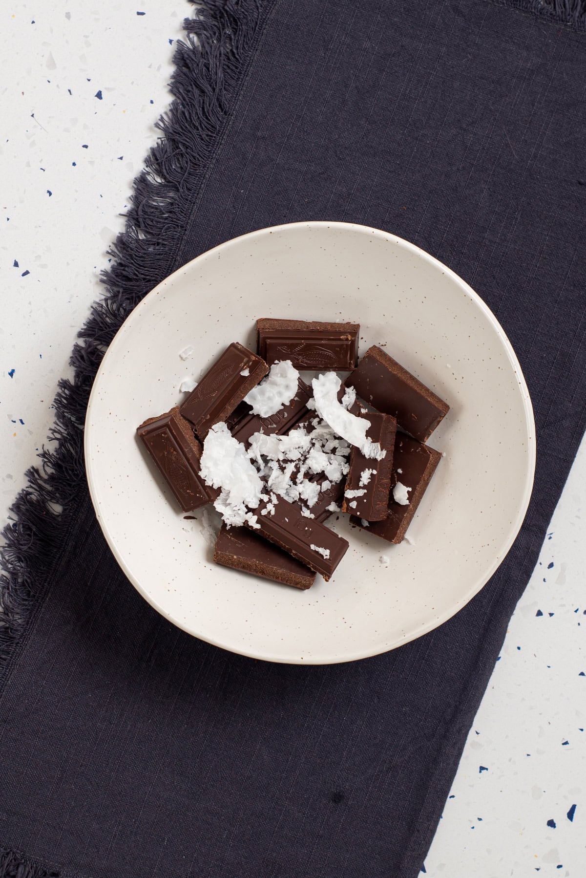 Chocolate pieces and coconut oil in a bowl ready for melting.
