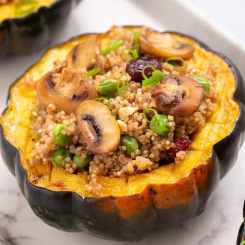 Close up view of stuffed acorn squash on a white plate.