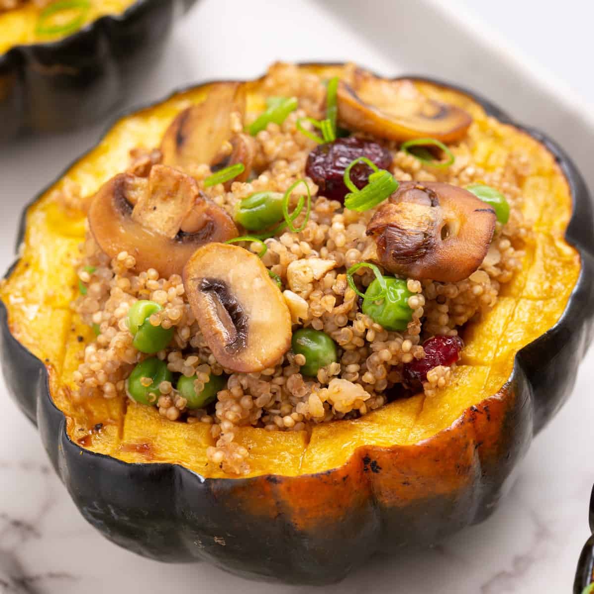 Close up view of stuffed acorn squash on a white plate.