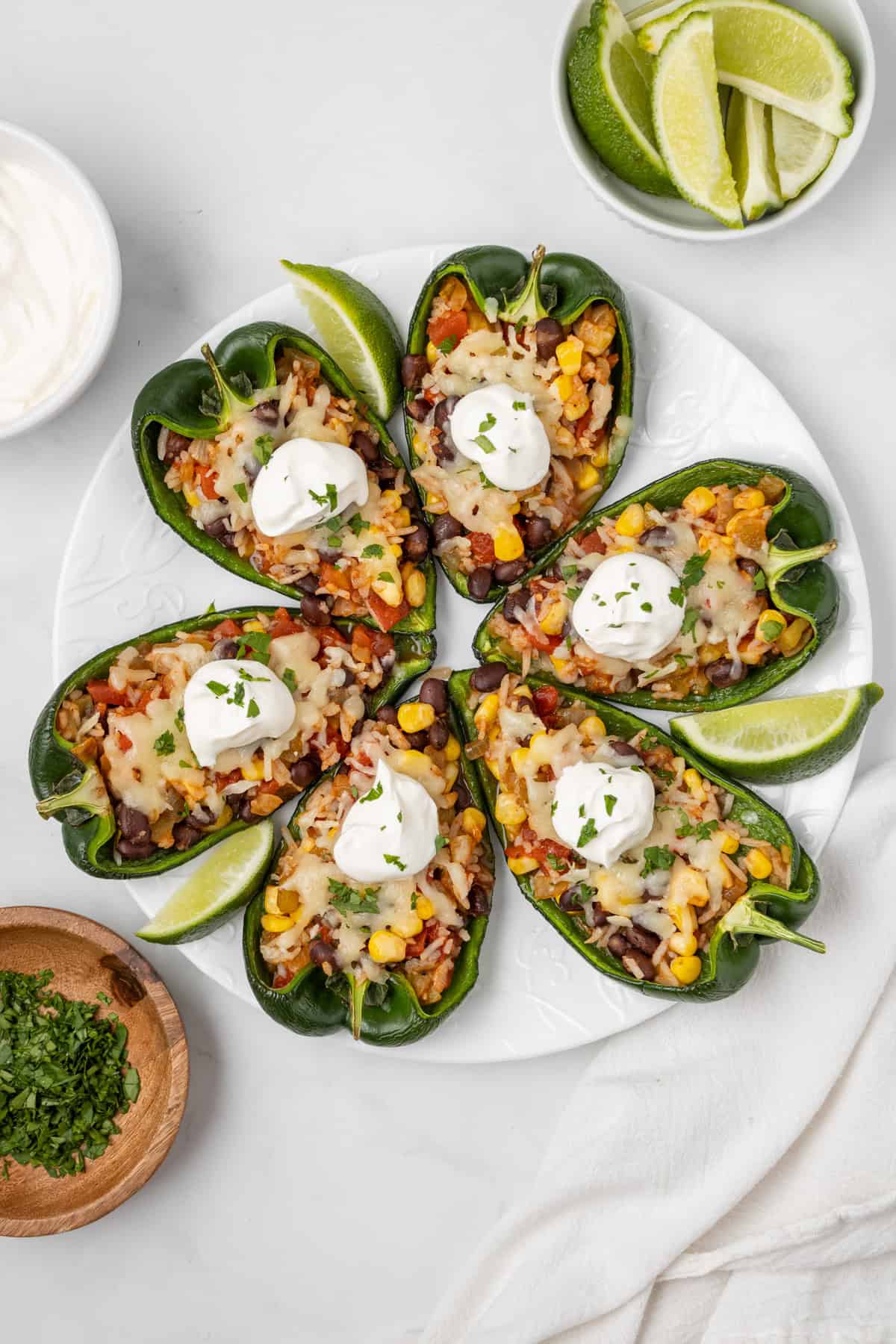 An overhead image of six pieces of stuffed poblano peppers arranged on a plate.