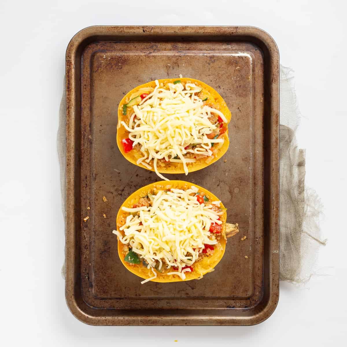 An image of mozzarella cheese being added on top of the stuffed squash.
