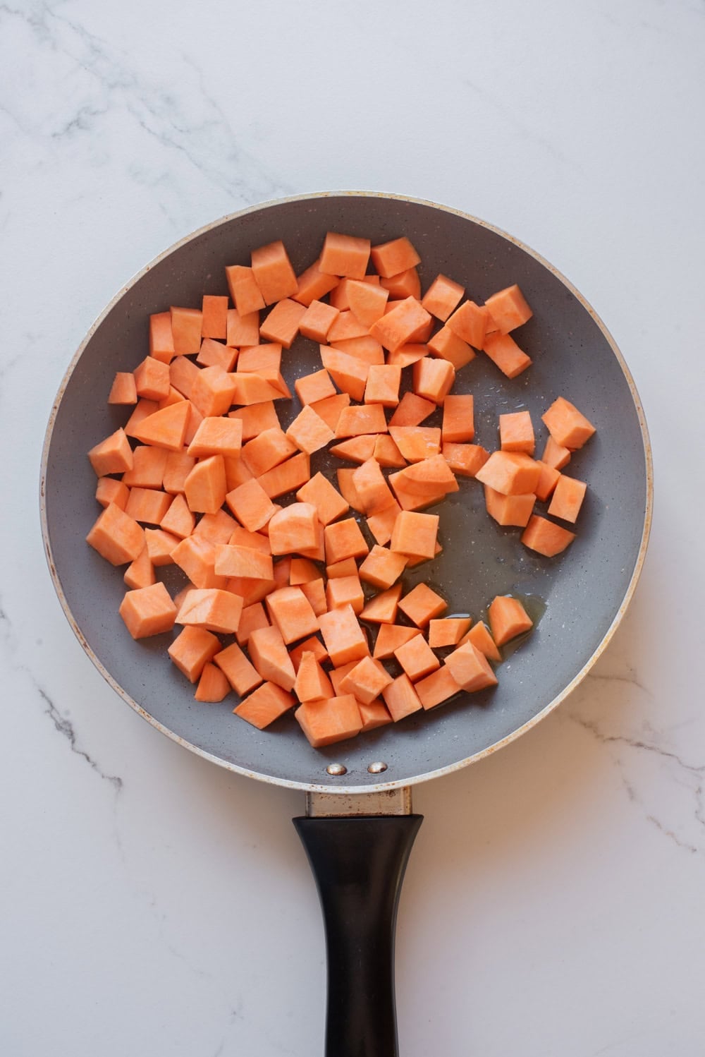 Sweet potatoes cooking in a skillet.