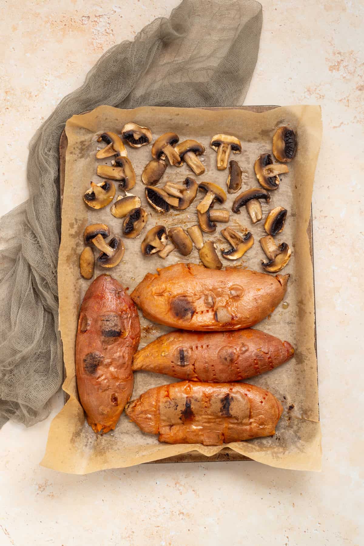 An image of baked sweet potato skins and mushrooms in a baking sheet.