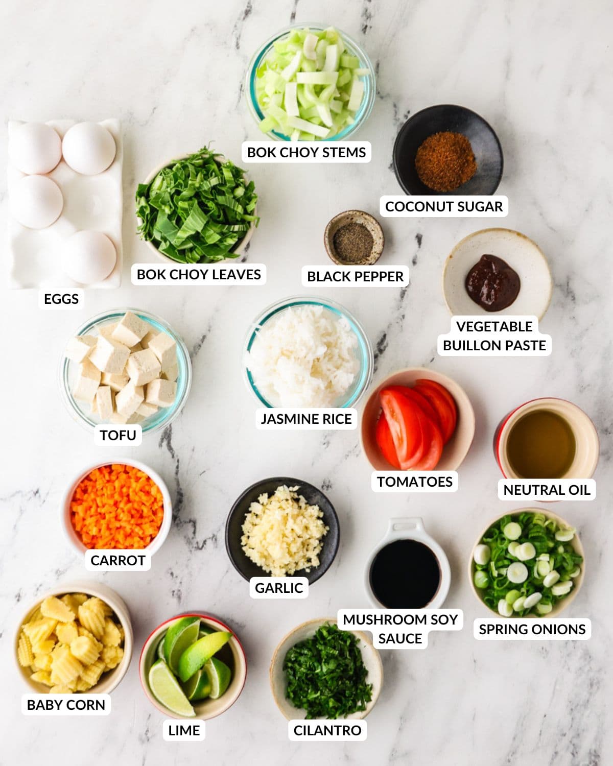 Ingredients for vegetarian Thai fried rice arranged on a marble surface.