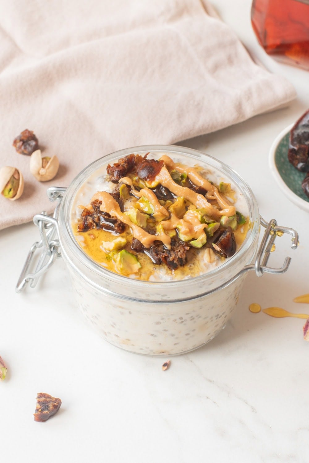 Close-up of tahini date overnight oats with toppings in a jar.