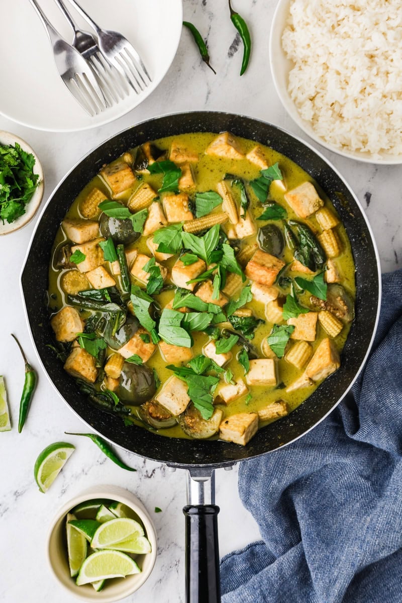 Thai green curry with tofu garnished with Thai basil leaves ready to serve.