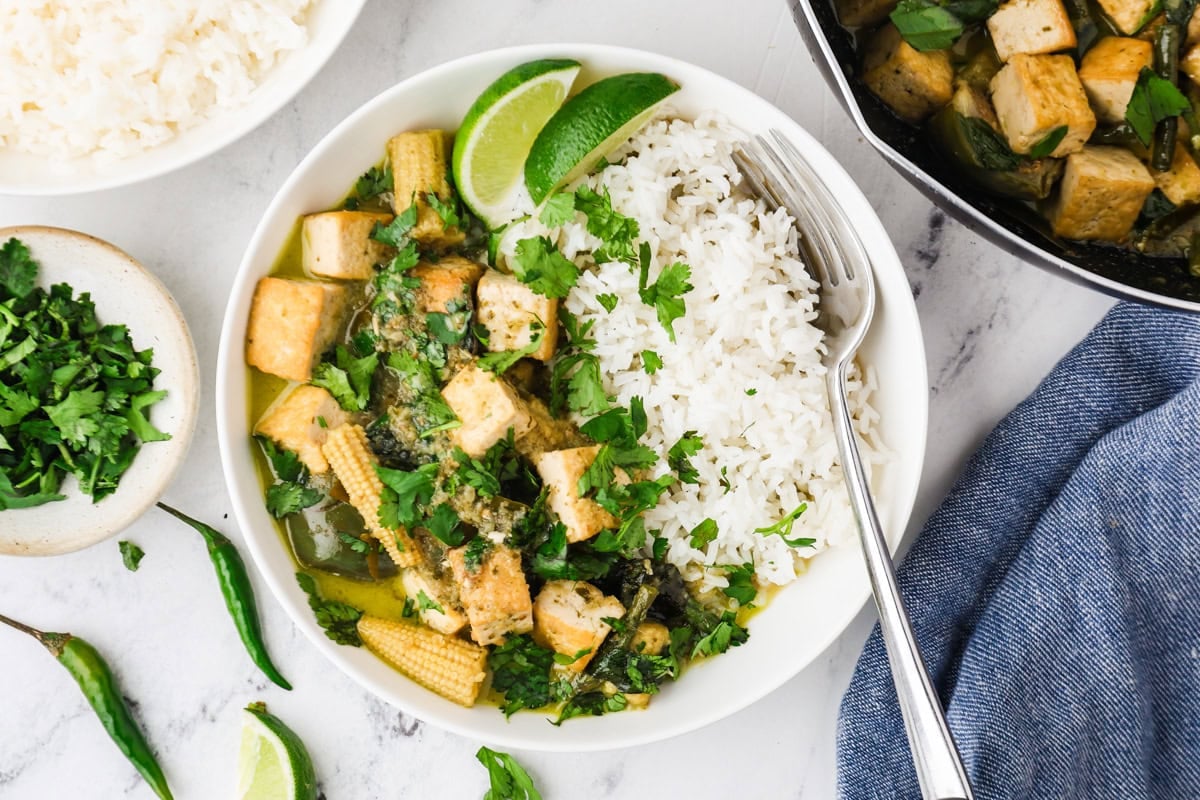 Overhead image of Thai green curry with tofu served with jasmine rice on a white plate.
