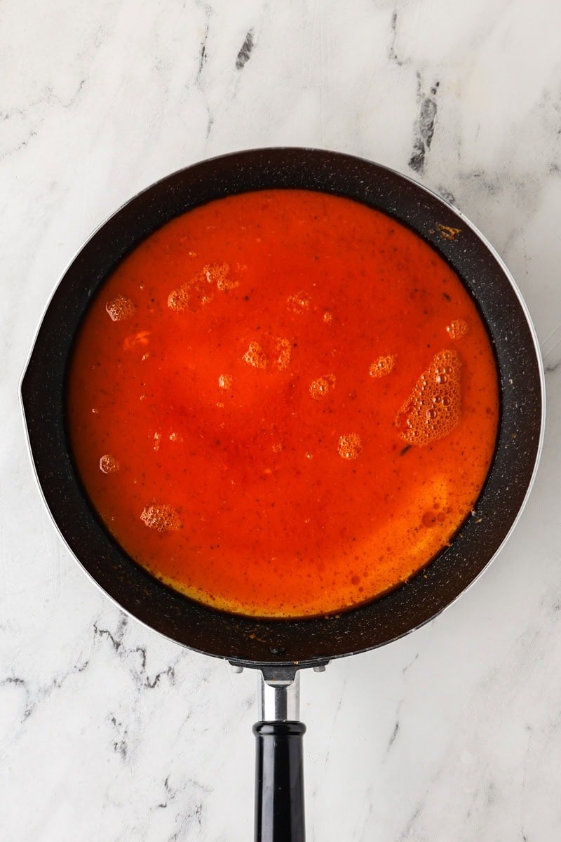 An overhead image of adding the thin part of coconut milk to the saucepan.