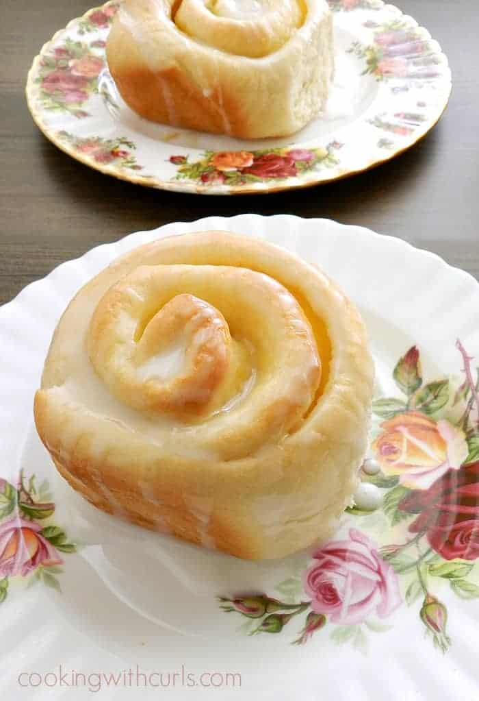 An overhead close-up view of two plates with lemon curd sweet roll.