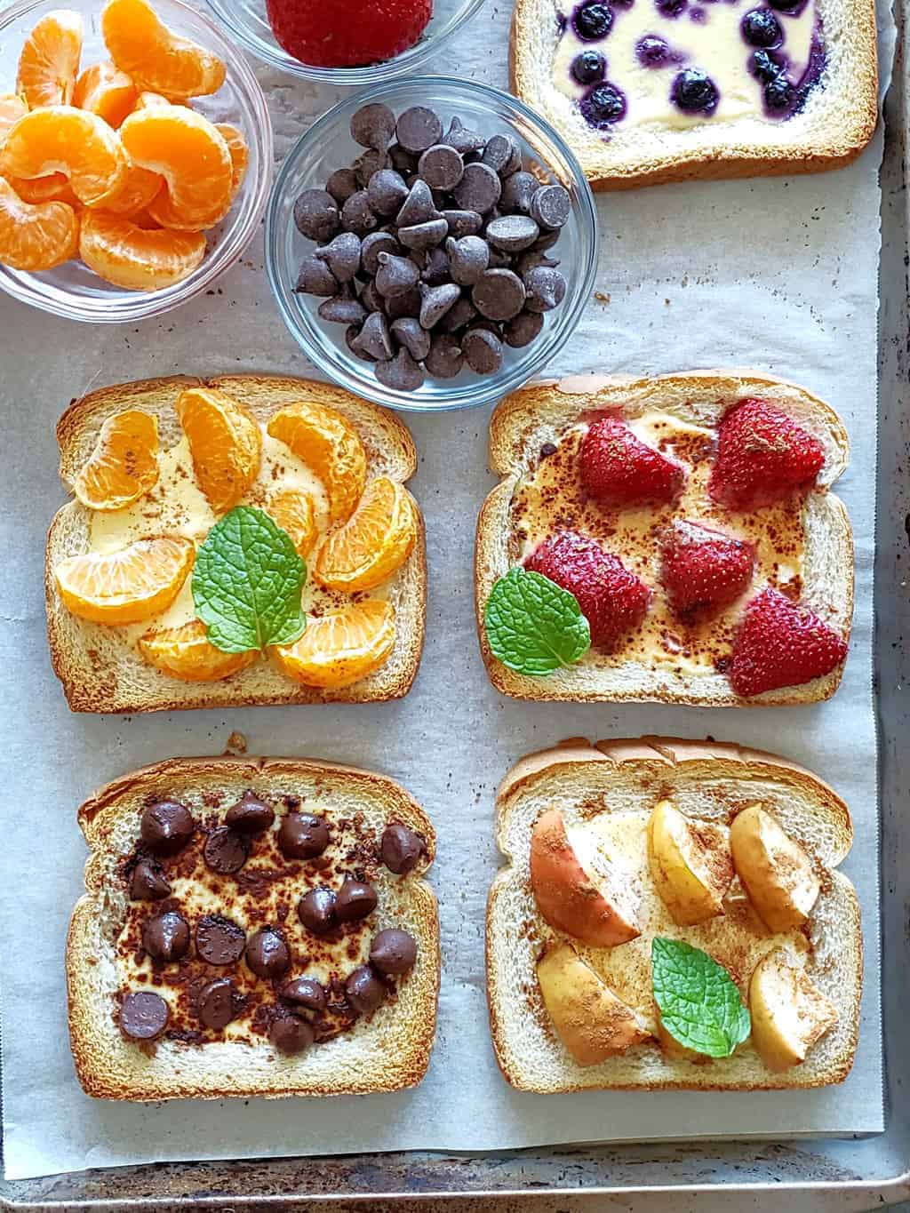 Overhead view of several yogurt toasts made with different fruits on top.