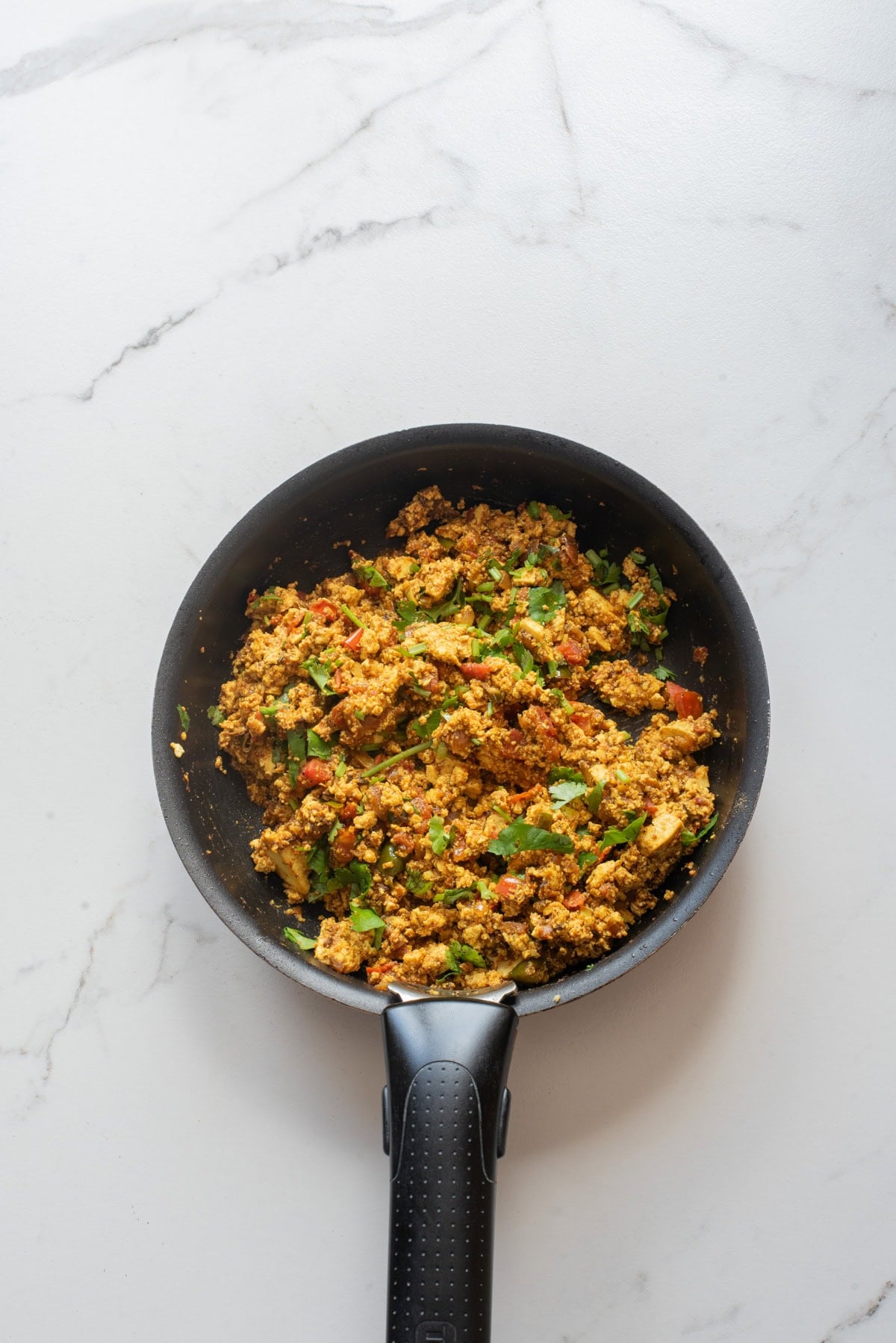 An overhead image of cooked tofu bhurji on a skillet.