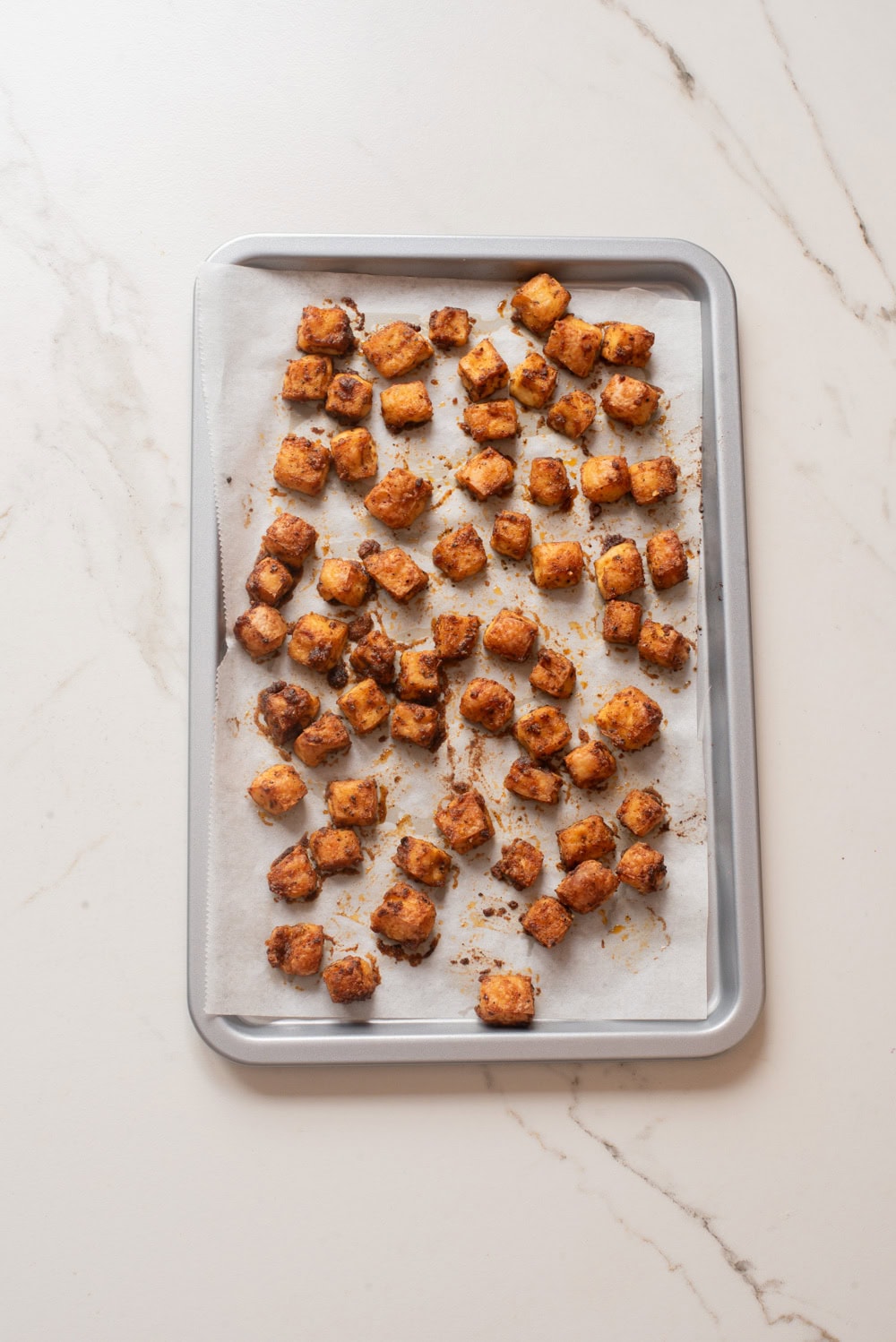Cooked tofu croutons on a baking sheet.