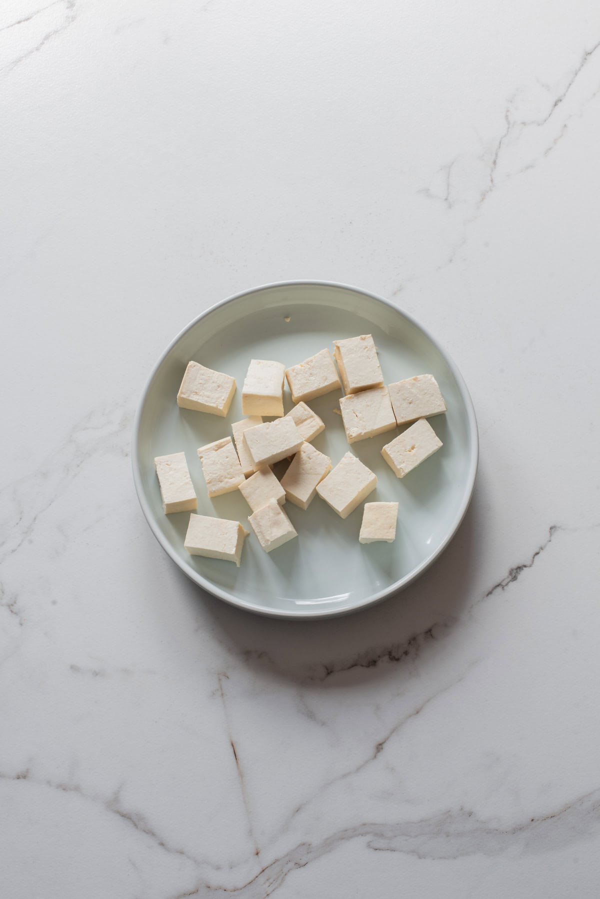 An overhead image of cutting the tofu in cubes.