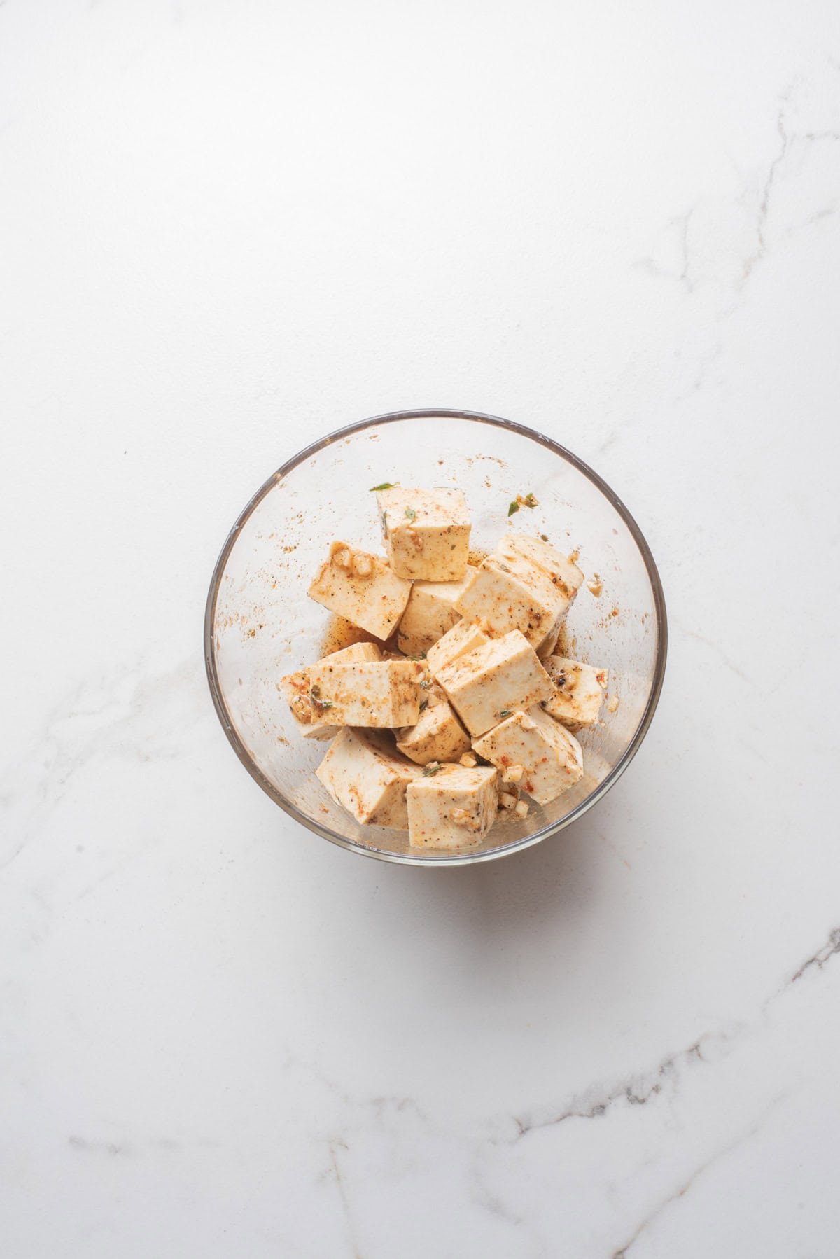 An overhead image of marinating tofu in a jerk mixture.