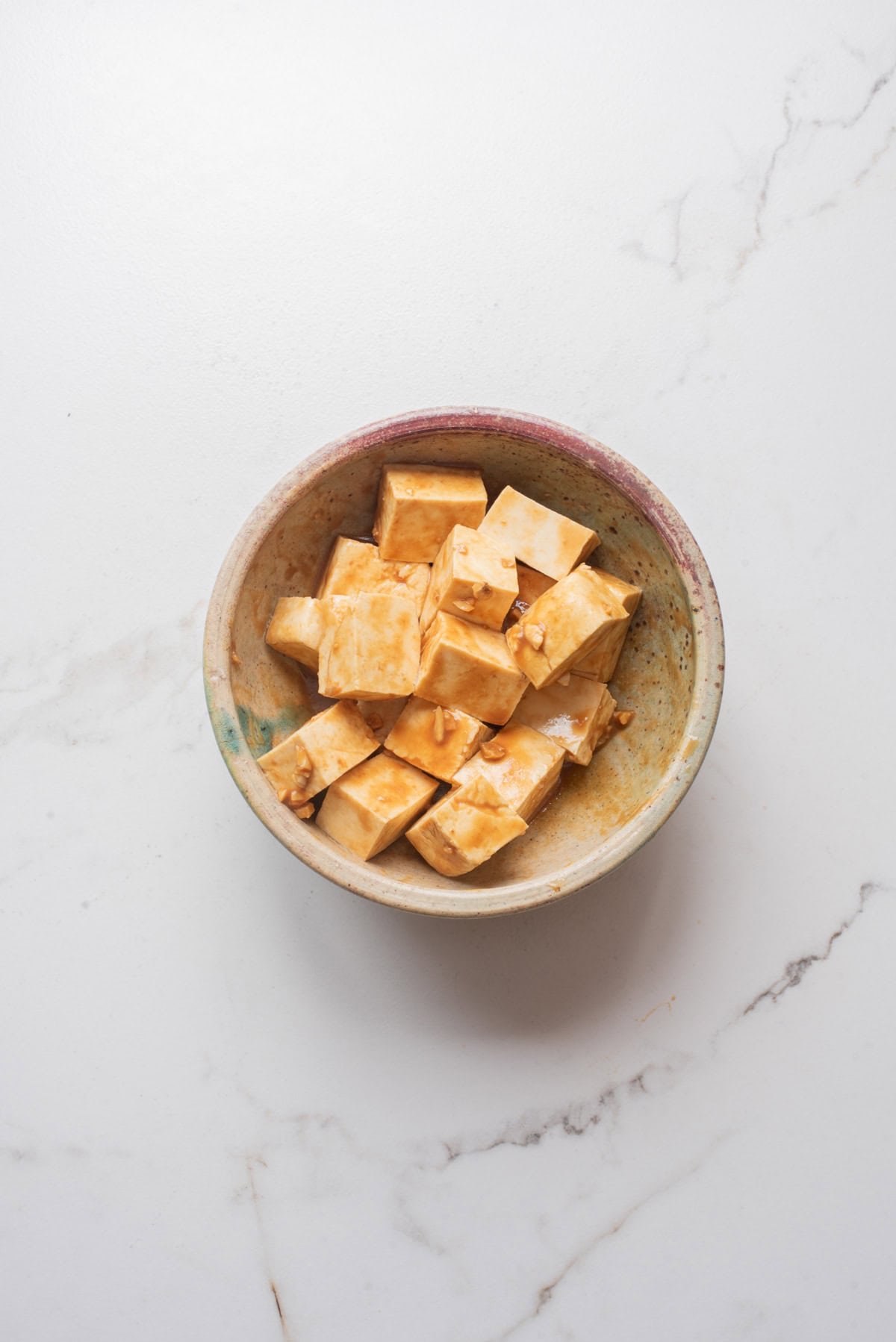An overhead image of tofu marinating in a miso marinade.