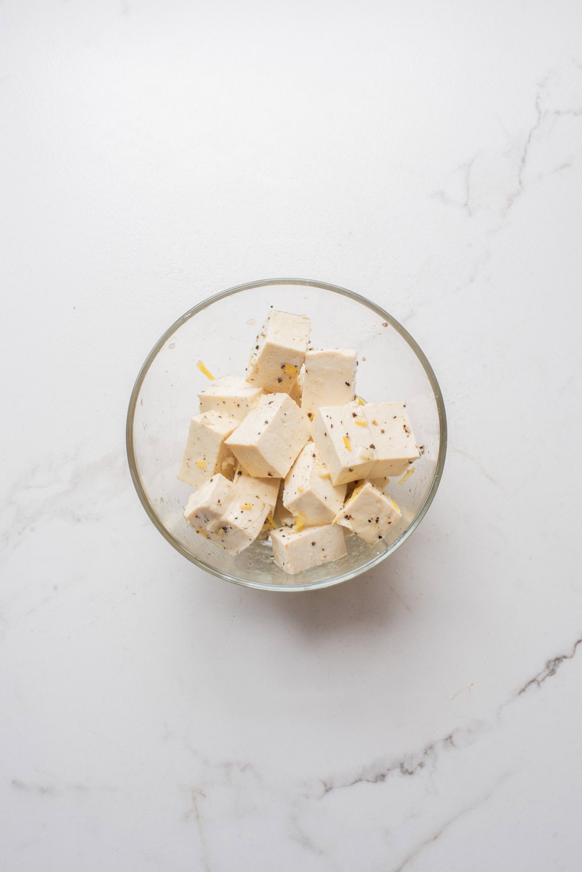 An overhead image of marinating the tofu in a lemon pepper mixture.