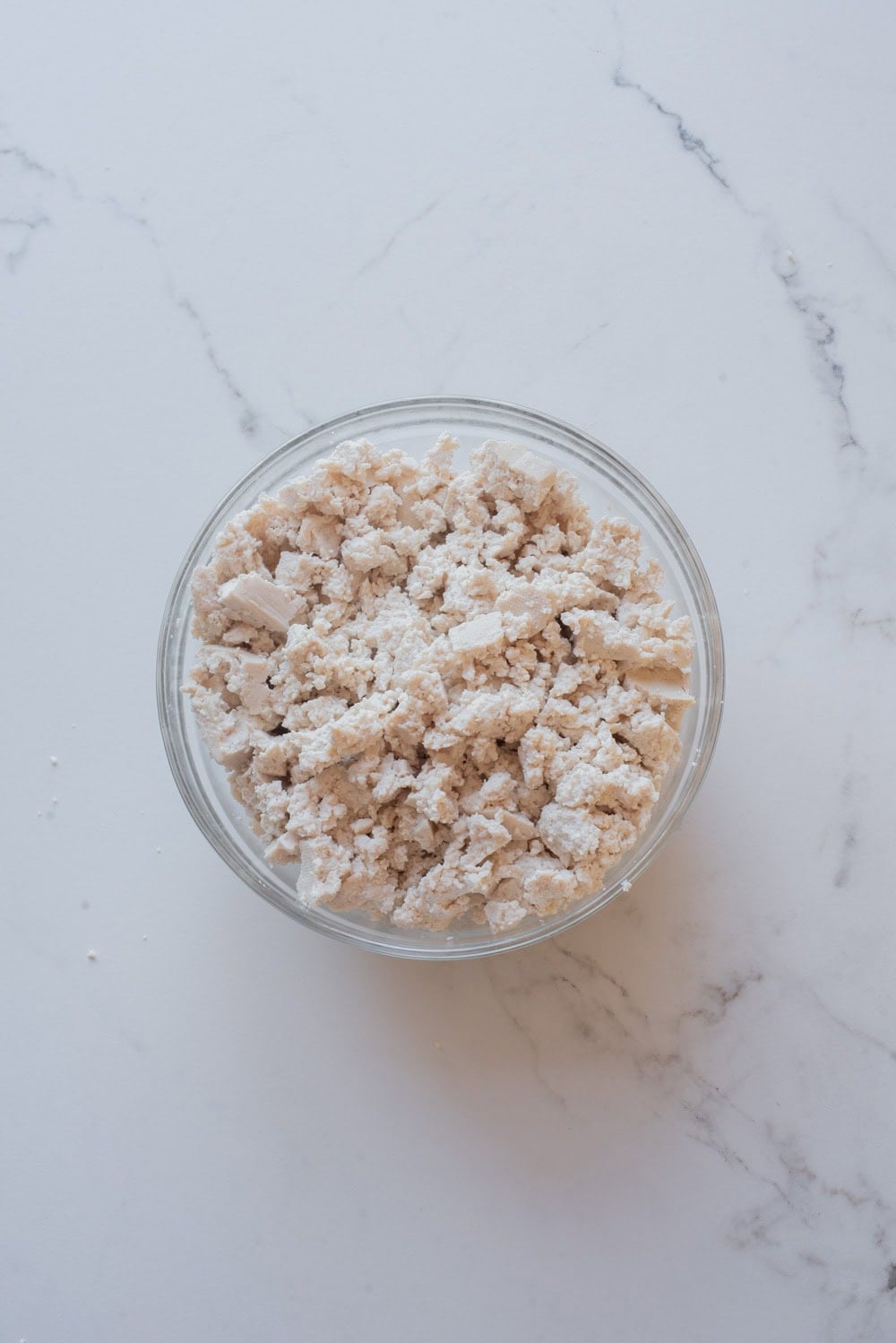 Crumbled firm tofu in a bowl ready to be used for tofu scramble.