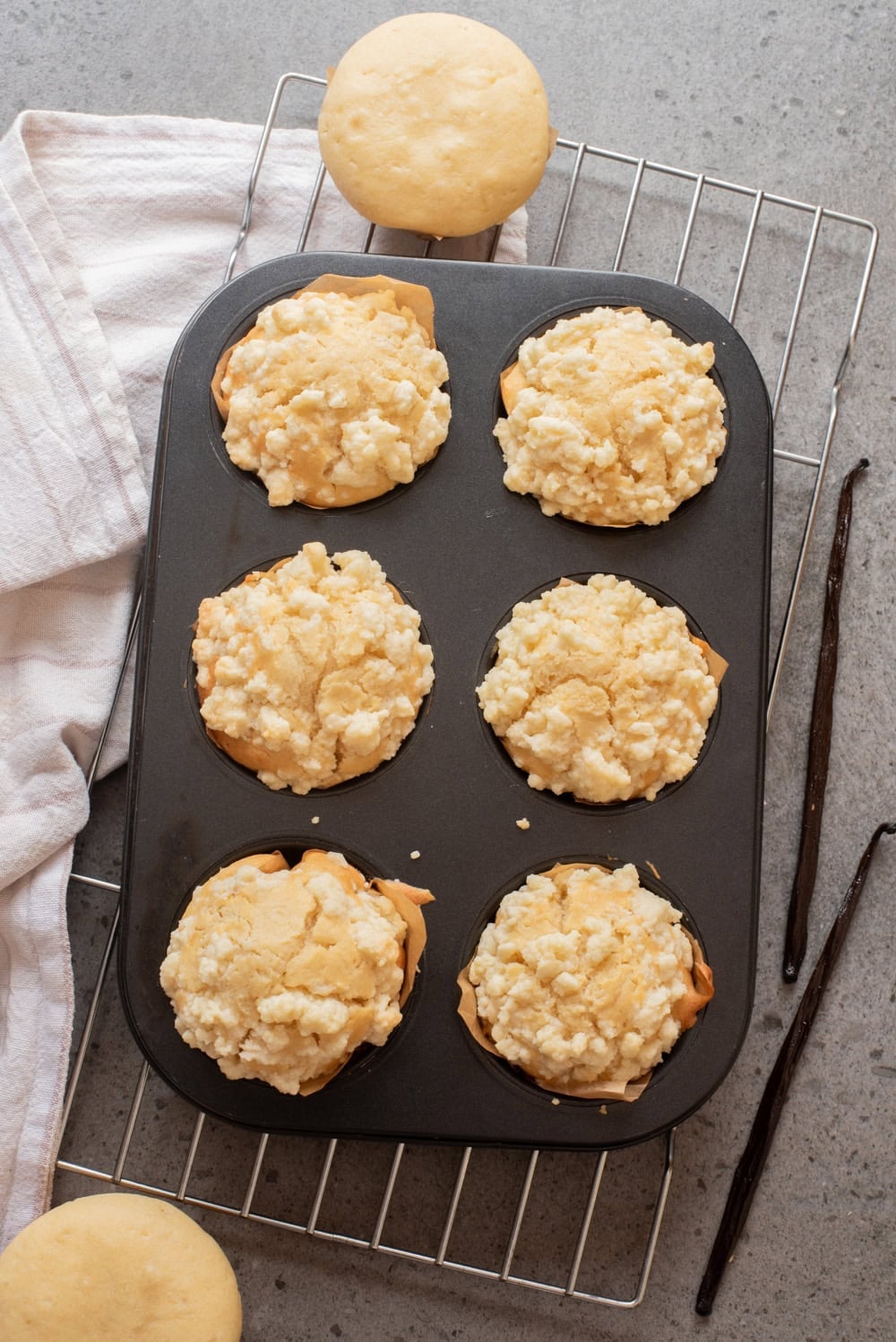 An overhead image of baked vanilla muffins in muffin cups.