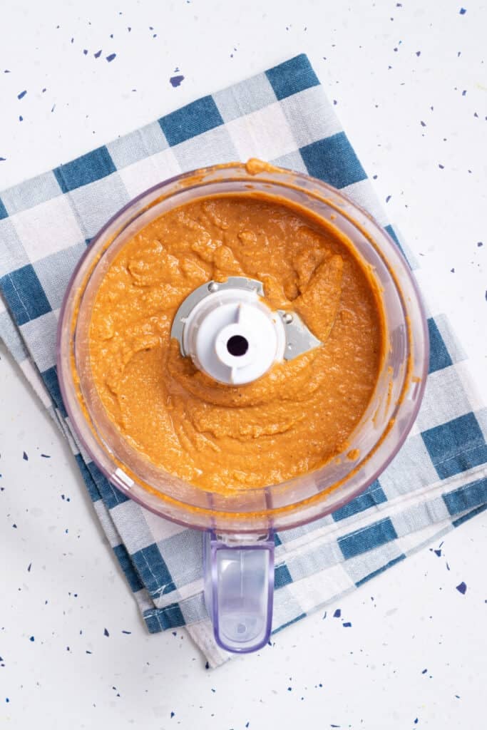 Overhead view of a food processor with mixed vegan ham ingredients.