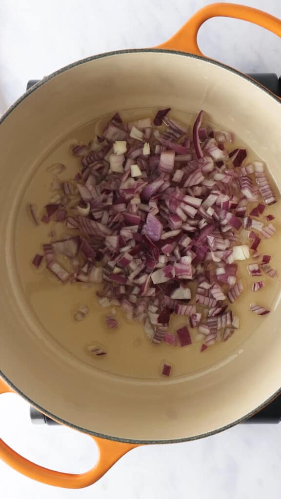 Adding onions to Dutch Oven.
