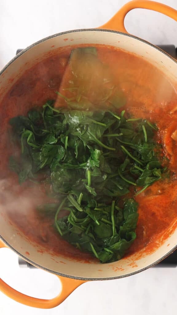 Add blanched spinach to the base in Dutch Oven.
