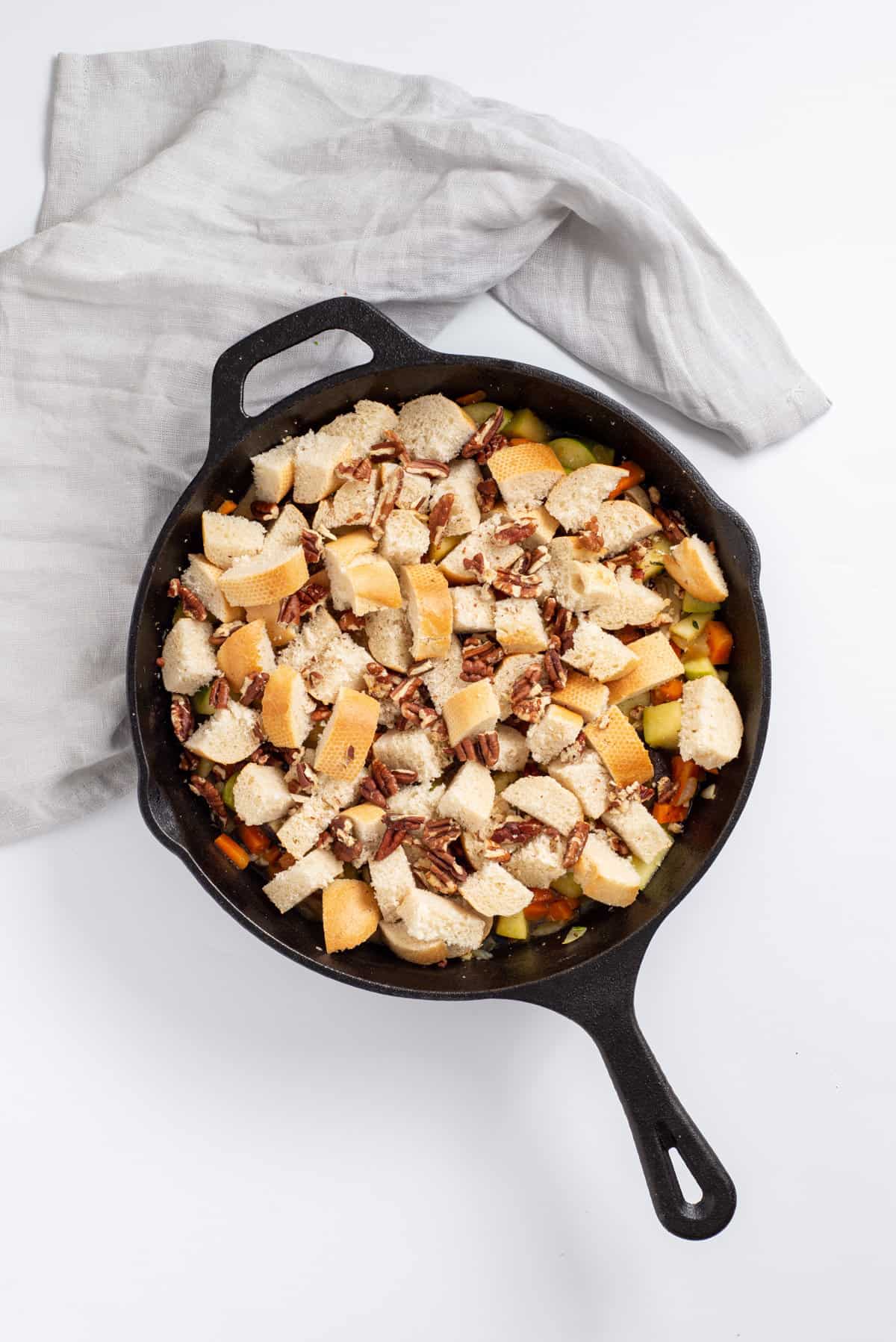 Overhead view of skillet with pecans and bread added in.