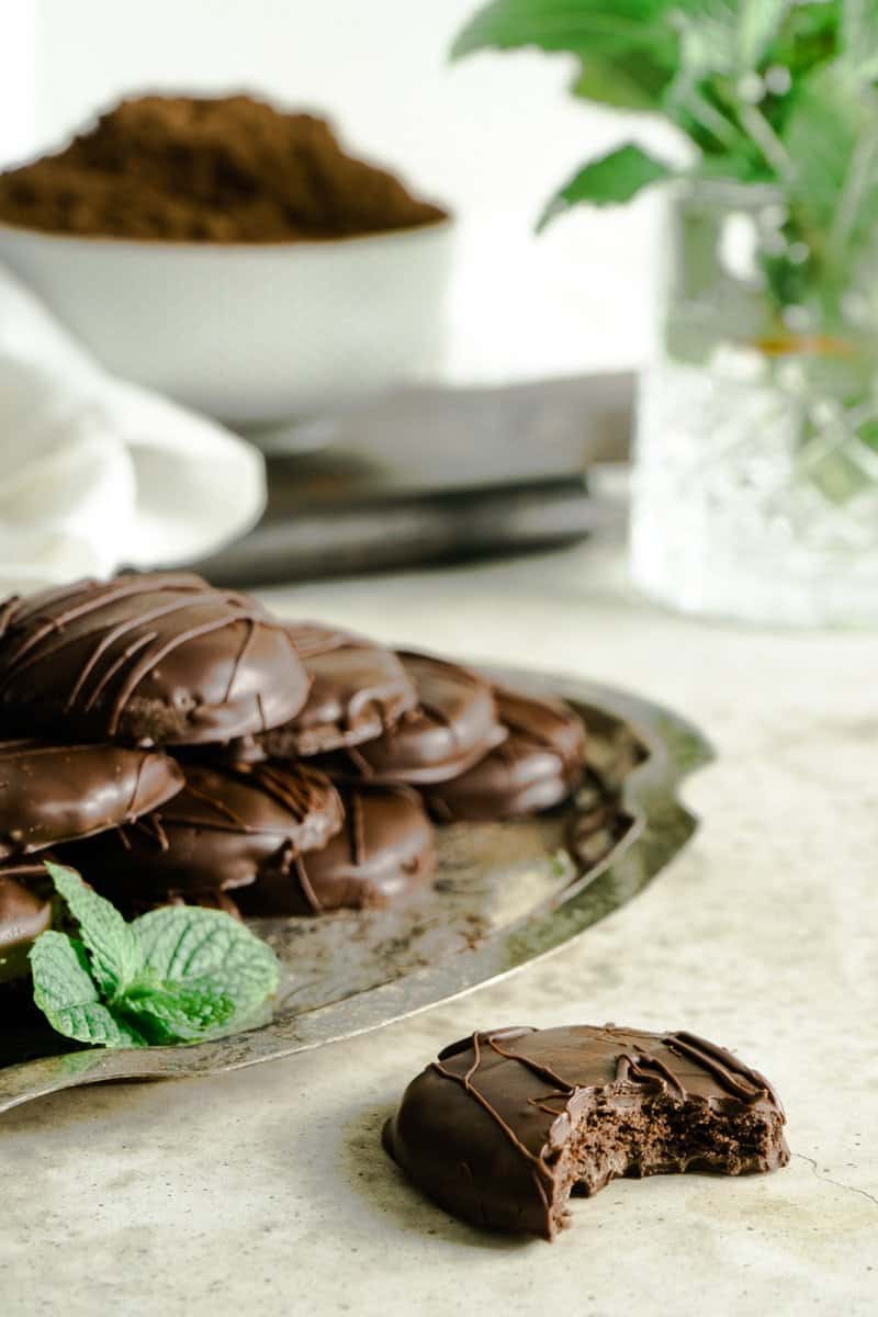 A straight side view shot of vegan thin mints layered in a gold platter.