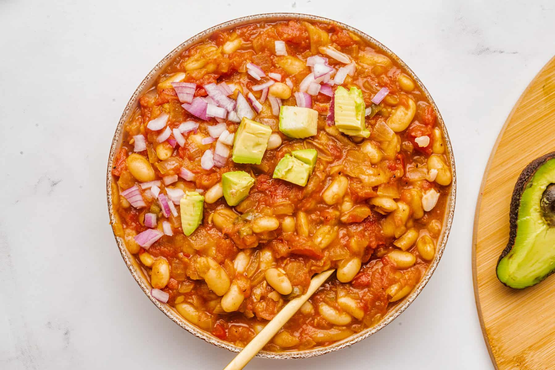 An overhead image of vegan white bean chili with toppings