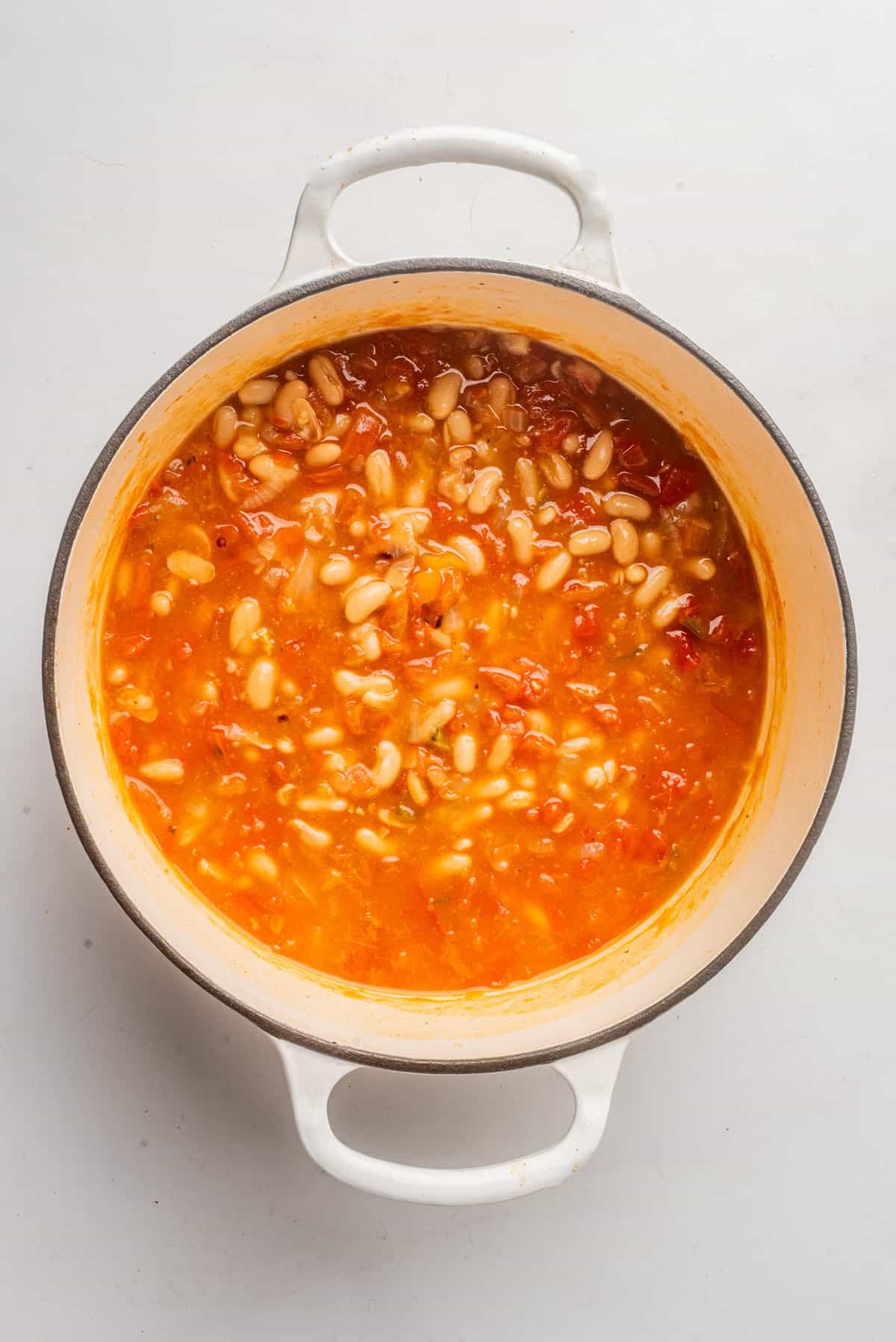 An overhead image of vegan white bean chili simmering in a pot