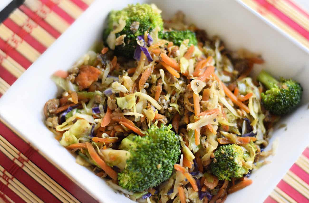 An overhead close-up shot of vegetable stir fry slaw on a white plate.