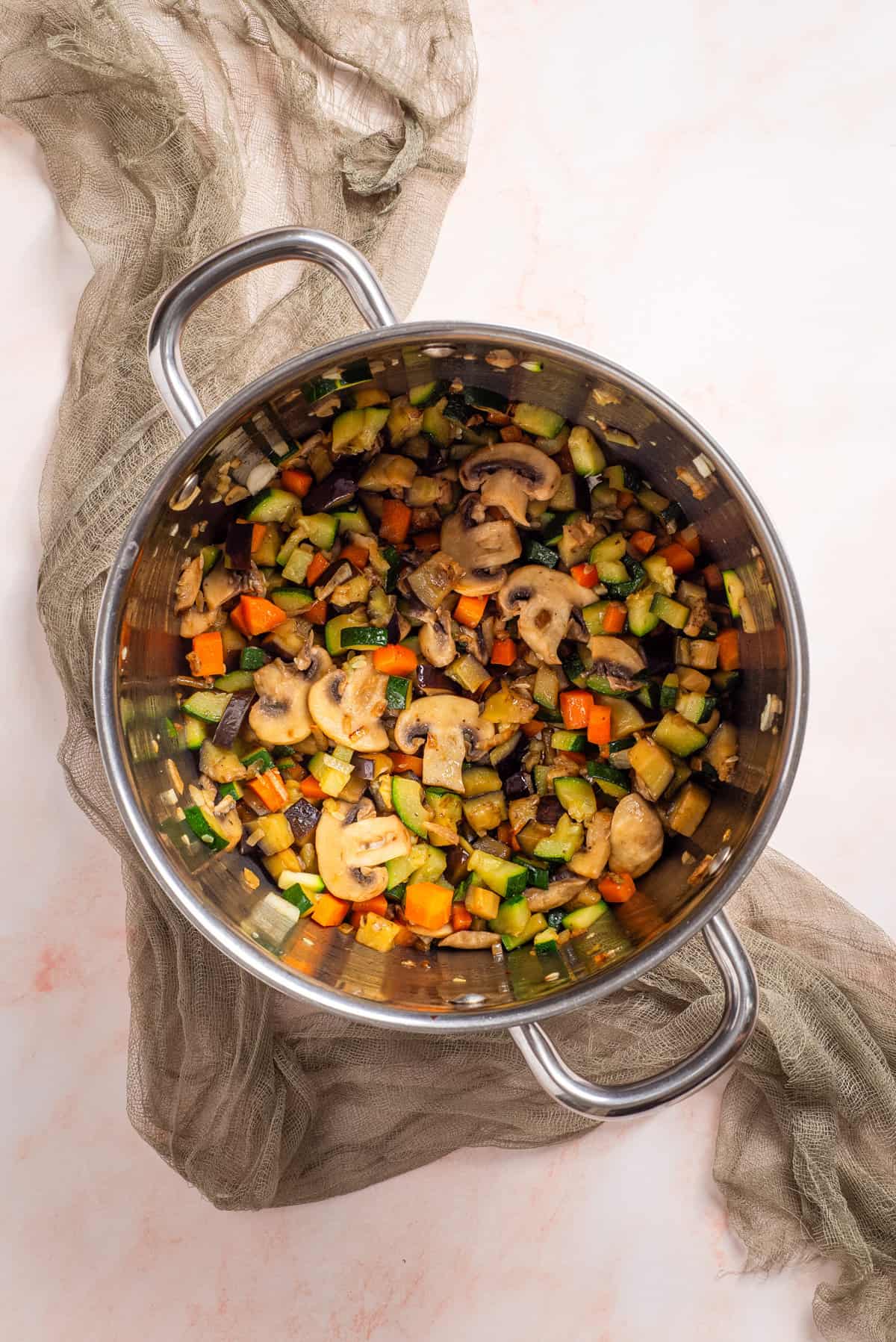 An overhead image of vegetables in a big pot.