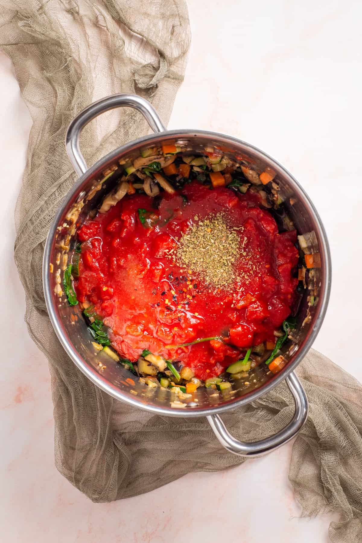 An overhead image of tomatoe sauce being added to a big pot.