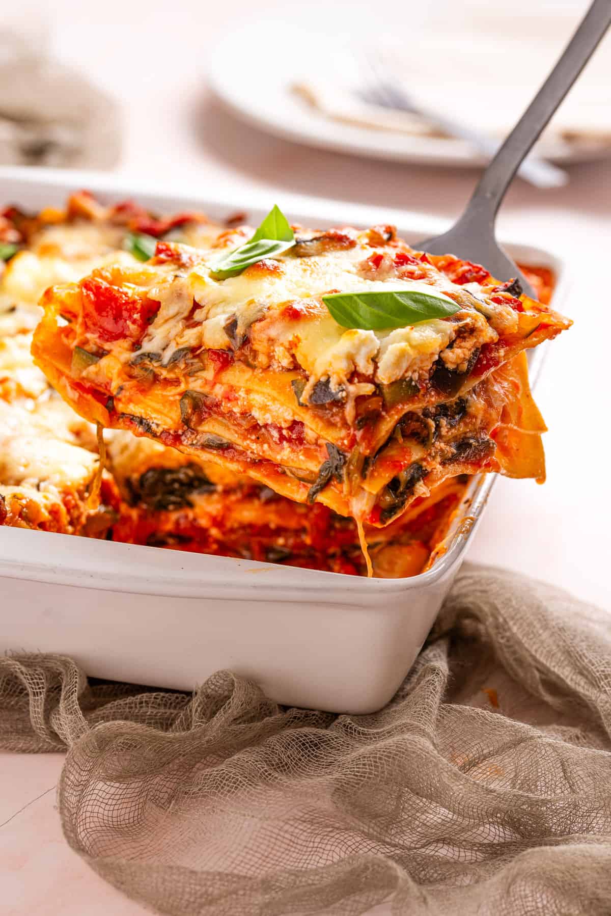 An image of baked cheesy vegetable lasagna in a baking dish.