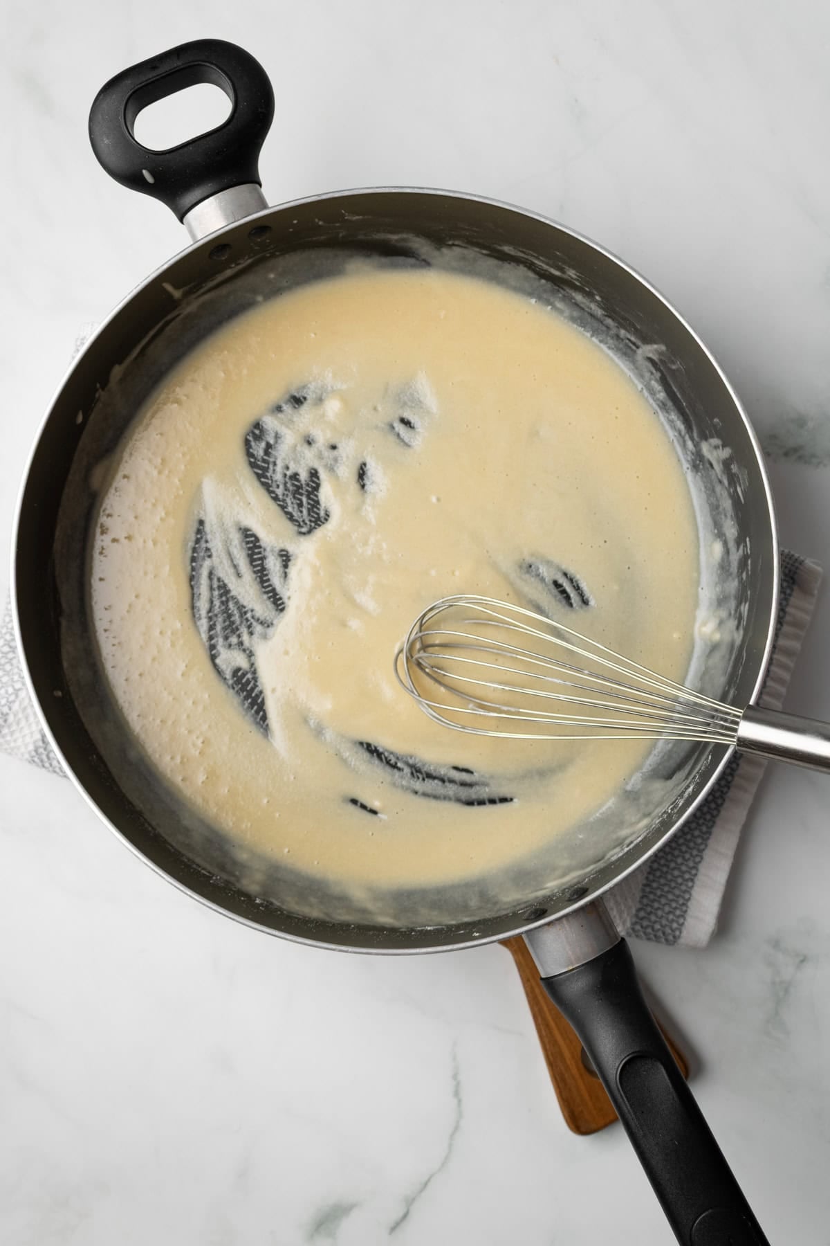 An overhead image of whisking the flour and butter together to make a roux.
