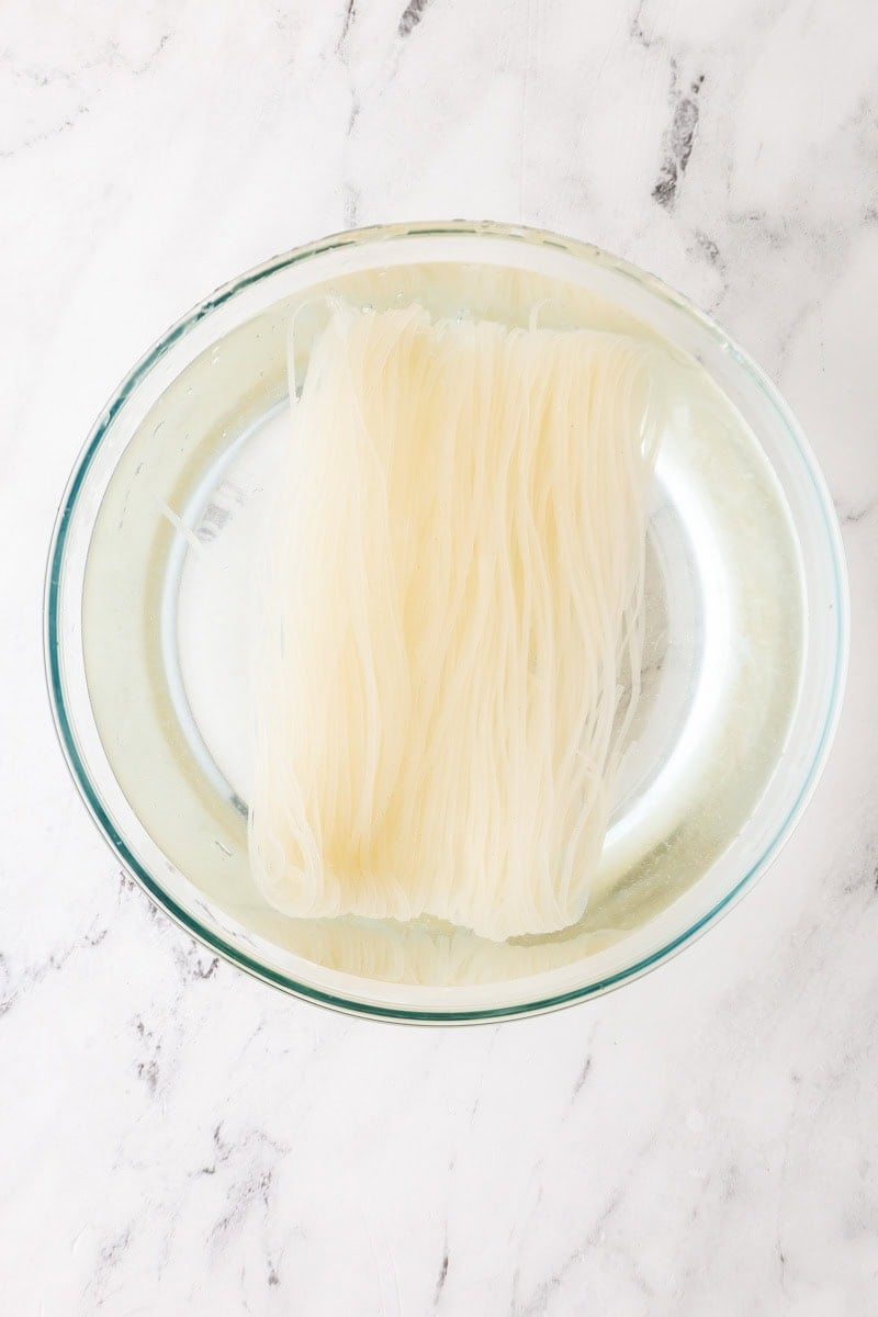 Soaking of dried pad thai rice noodles in hot water.