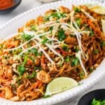 Plated tofu pad thai without tamarind topped with peanuts, cilantro, and fresh bean sprouts.