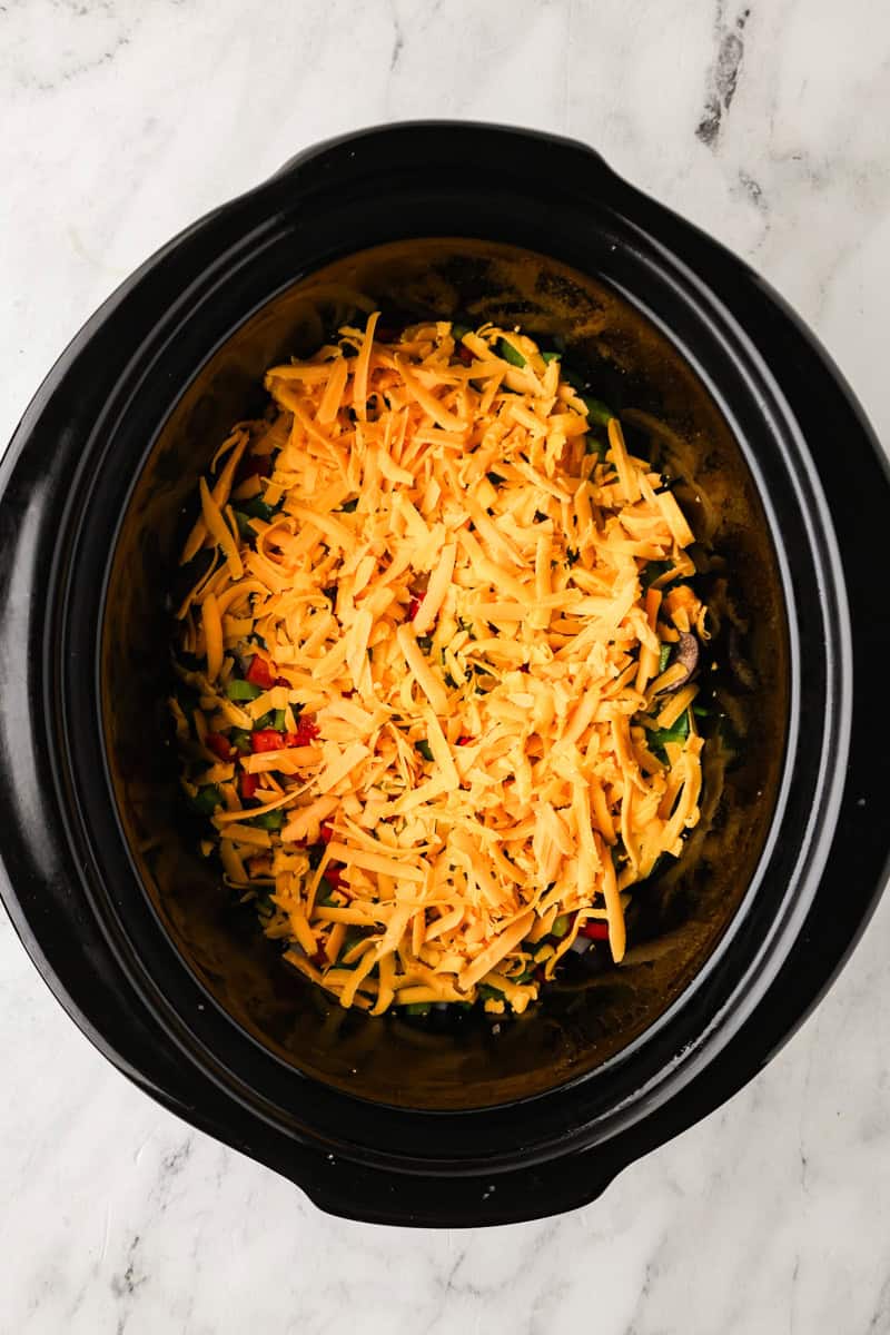 An overhead image of adding layers to the slow cooker.
