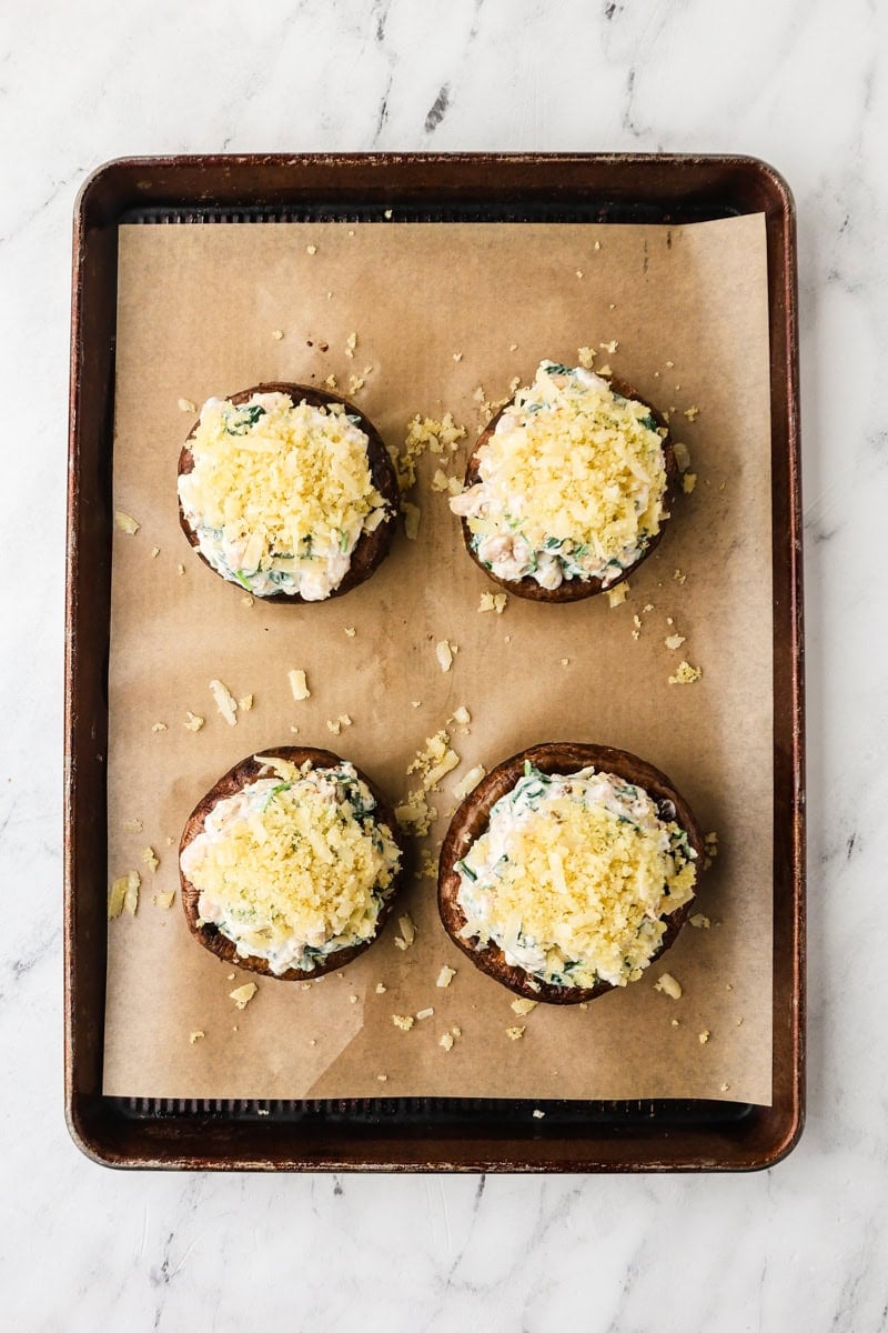 An overhead image of topping the mushrooms with the panko and parmesan mixture.