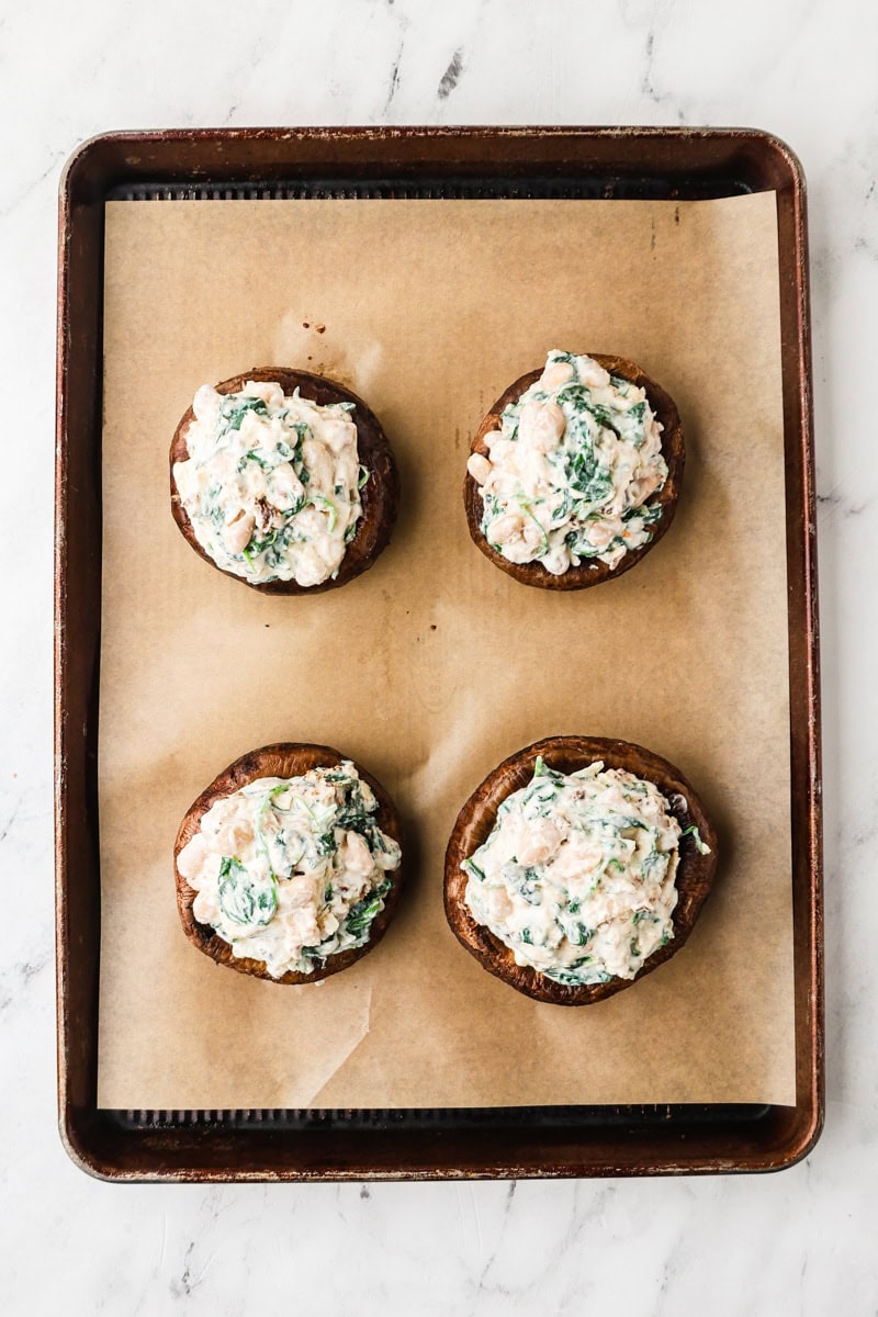 An overhead image of portobello mushrooms on a baking sheet.