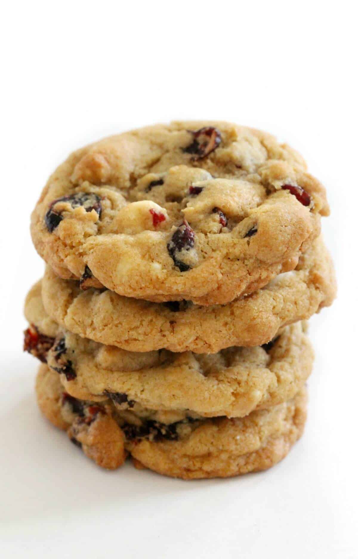 A close-up shot of stacked vegan white chocolate cranberry cookies.
