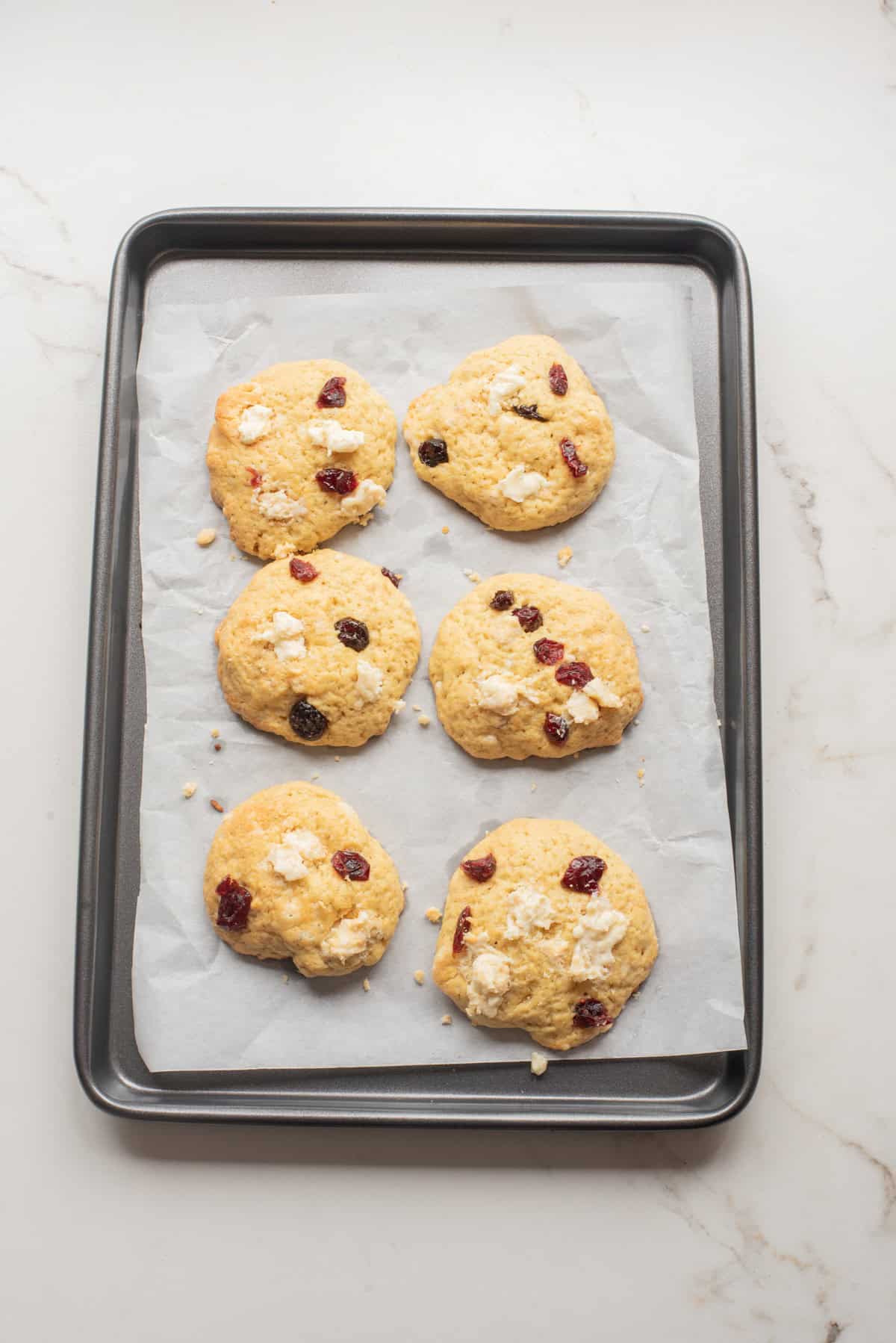An overhead image of baked white chocolate cranberry cookies on a baking sheet.