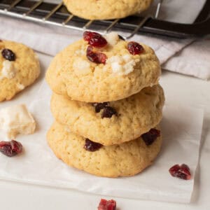 An image of three pieces of white chocolate cranberry cookies stacked on top of each other.