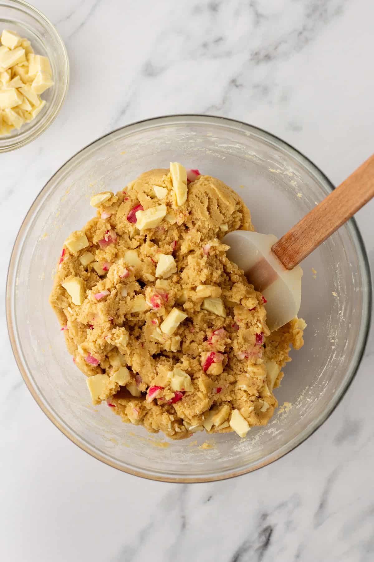 An overhead image of mixing in white chocolate bar and peppermint candies.