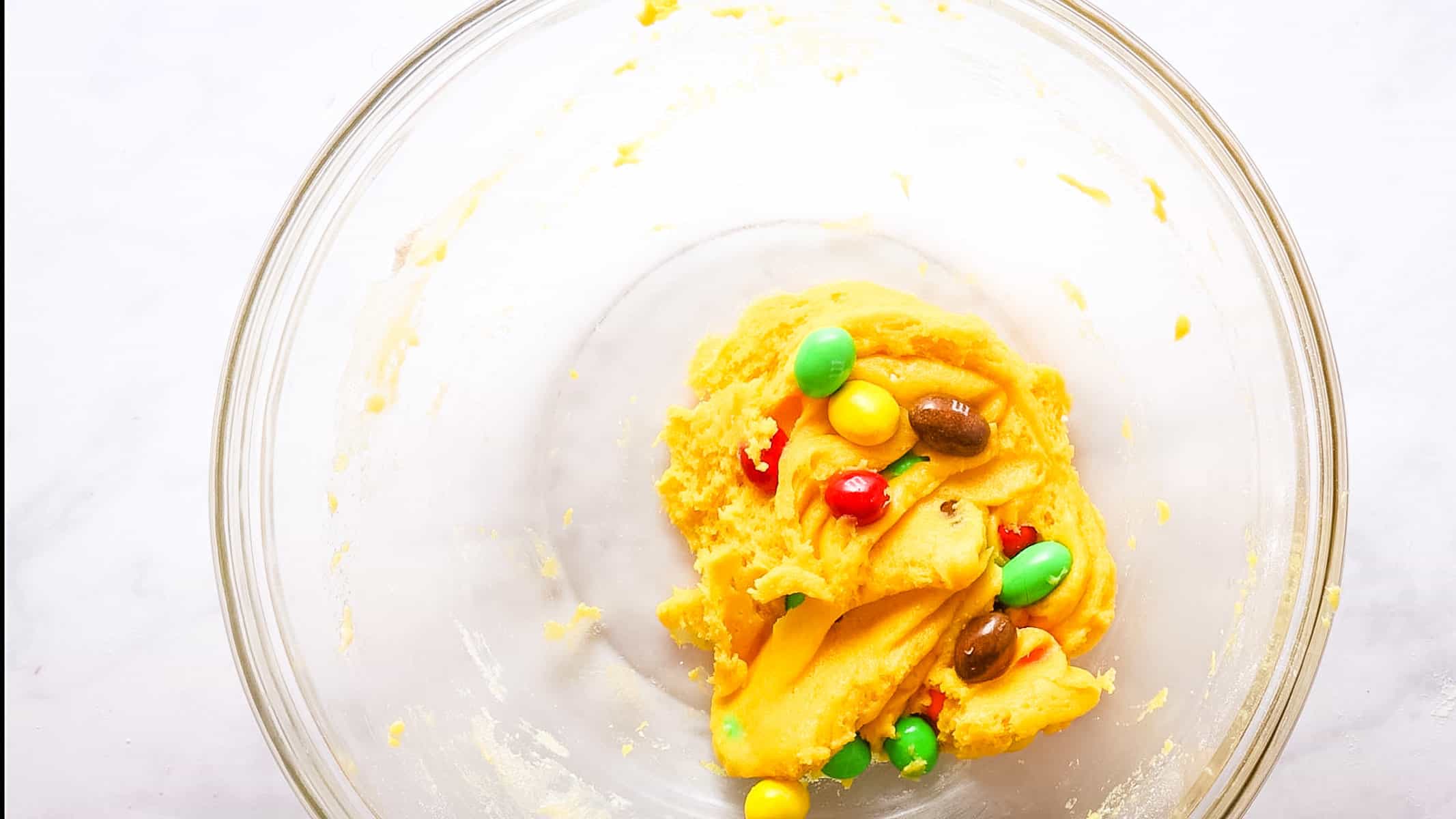 Overhead view of M&Ms into the cookie dough, after mixing in.