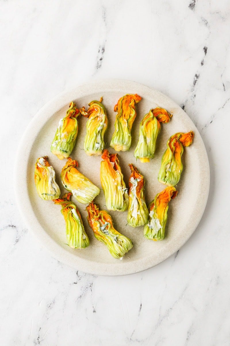Zucchini blossoms filled with ricotta mixture and twisted closed.