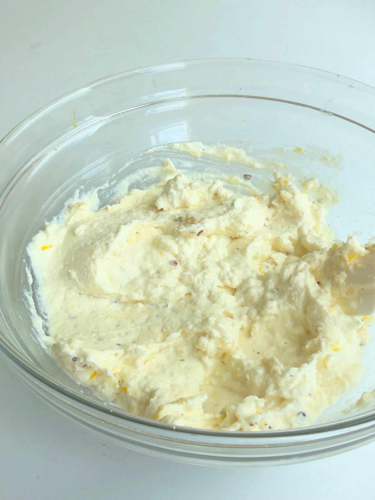 Lemon ricotta filling stirred until smooth for zucchini puff pastry tart.