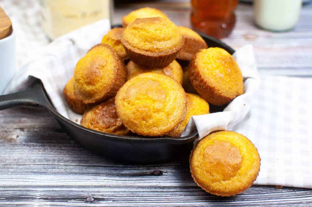 A straight view of several air-fried cornbread muffins placed on a black bowl.