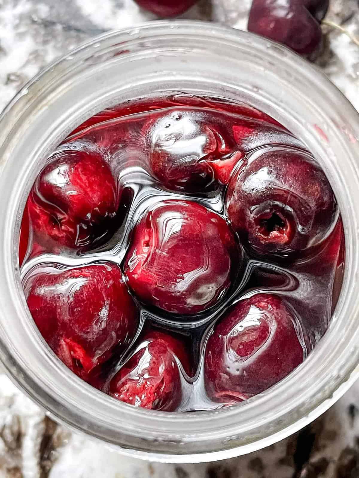 Image showing top down view of brandied cherries in a glass jar.