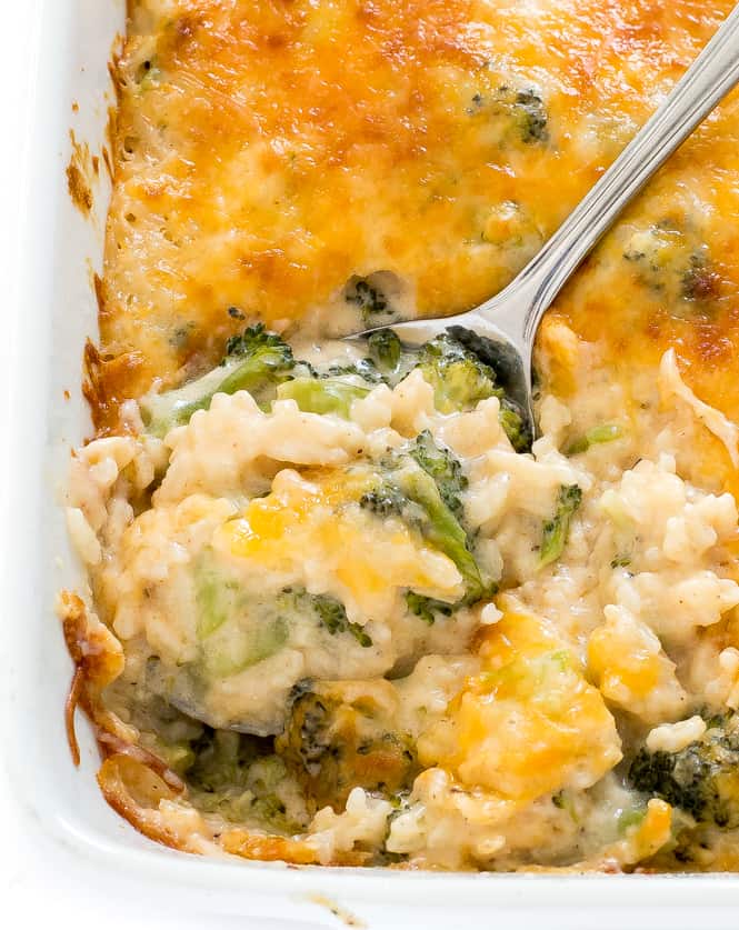 Overhead view of broccoli rice cheese casserole with a spoon scooping the dish out.